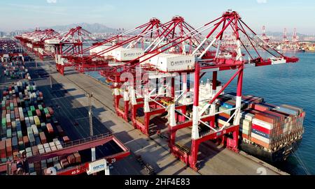 QINGDAO, CHINE - le 14 JANVIER 2022 - Un cargo est vu charger et décharger des marchandises au terminal entièrement automatisé du port de Qingdao dans le SH de la Chine orientale Banque D'Images