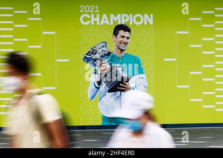 Melbourne, Australie, 14th janvier 2022.Un homme et une femme marchent devant un mur montrant le vainqueur de l'année dernière, Novak Djokovic.Credit: Frank Molter/Alamy Live News Banque D'Images