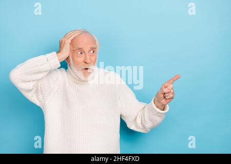 Portrait de l'homme à cheveux gris effrayés et attrayant montrant la copie espace vide isolé sur fond bleu clair Banque D'Images