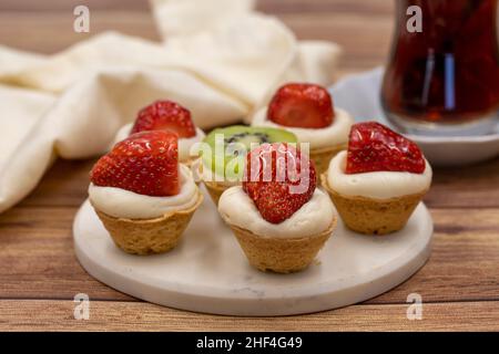 De délicieuses petites tartelettes sur fond de bois. Gros plan Banque D'Images