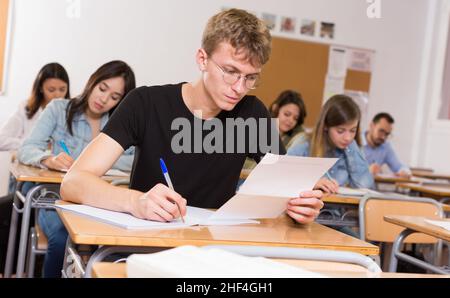 L'étudiant est en position assise et répond à la tâche Banque D'Images