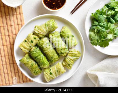 Des rouleaux de chou farcis de style chinois sur fond de pierre blanche.Vue de dessus, plan d'appartement Banque D'Images