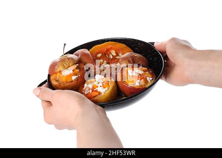 Les mains des femelles tiennent la plaque avec des pommes cuites, isolées sur fond blanc Banque D'Images