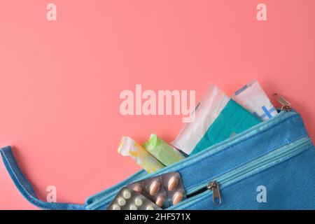 Trousse de toilette avec produits d'hygiène menstruelle pour femmes sur fond rose.Vue de dessus. Banque D'Images