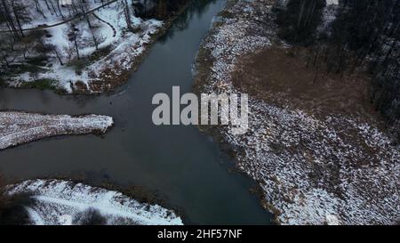 Vol au-dessus du parc enneigé.La rivière est visible.Photographie aérienne. Banque D'Images