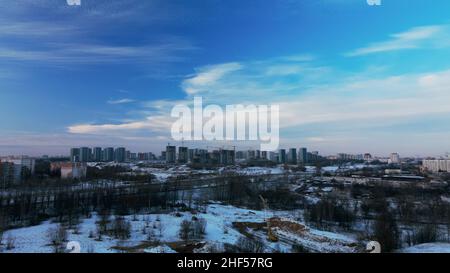 Vol au-dessus d'un parc enneigé.La ville est visible à l'horizon.Photographie aérienne. Banque D'Images