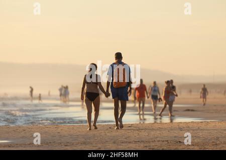 Zahara de los Atunes, Espagne - 03 septembre 2021: Un couple, tenant les mains, profitez d'une promenade sur la plage, au coucher du soleil, province de Cadix Banque D'Images