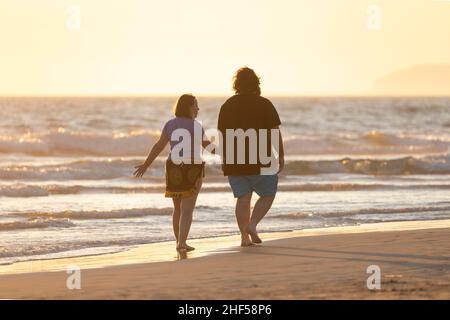 Zahara de los Atunes, Espagne - 03 sept, 2021: Un couple, profitez d'une promenade sur la plage tout en discutant au coucher du soleil, province de Cadix Banque D'Images
