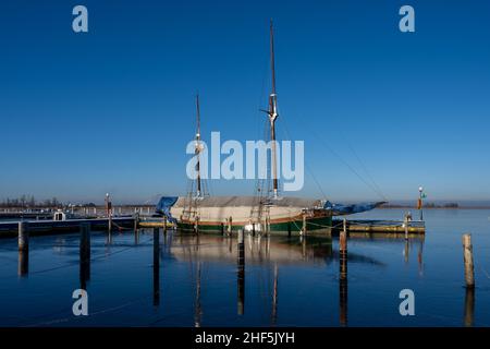 Un voilier dans une marina fermé pour l'hiver.Eau bleue et ciel bleu clair Banque D'Images