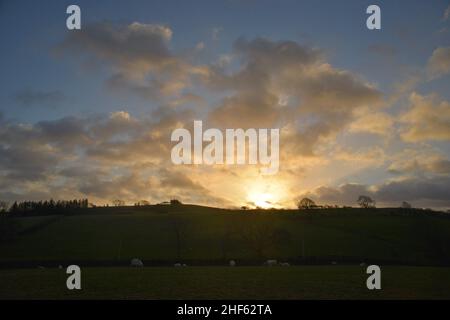 Lever de soleil sur les terres agricoles à Gwyddelwern, Denbighshire, pays de Galles du Nord au Royaume-Uni. Les rayons Crespusculaires qui en ont résulté ont été spectaculaires. Banque D'Images