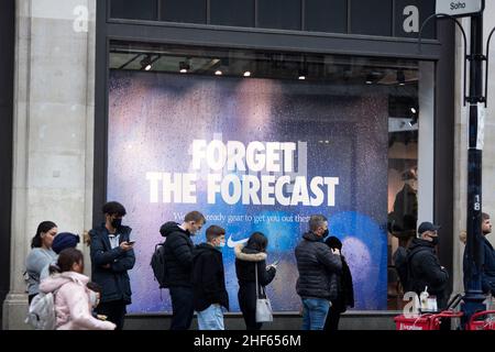 Les gens font la queue devant une publicité intitulée « Forget the Forecast » à l'extérieur d'un magasin Nike Town le lendemain de Noël dans le centre de Londres. Banque D'Images