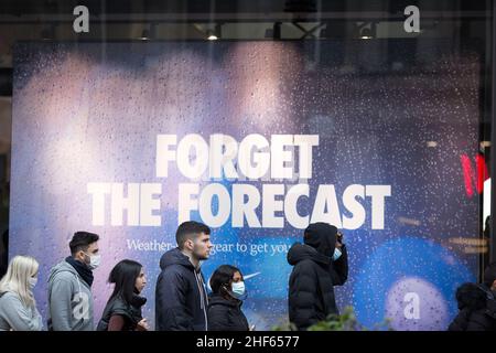 Les gens font la queue devant une publicité intitulée « Forget the Forecast » à l'extérieur d'un magasin Nike Town le lendemain de Noël dans le centre de Londres. Banque D'Images