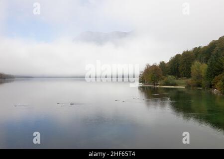 Le brouillard du matin au lac Wochein se dissipe et les montagnes deviennent visibles, Slovénie, 15.10.2021. Banque D'Images