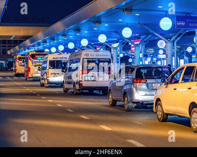 Taxis et bus attendant la nuit pour les passagers arrivant au terminal national de l'aéroport international de Tan son Nhat à Ho Chi Minh ville, Vietnam. Banque D'Images