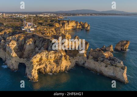 Portugal, Algarve, Lagos, Ponta da Piedade le matin, vue aérienne, vue de la mer, promontoire, rochers, phare, Lagos en arrière-plan Banque D'Images