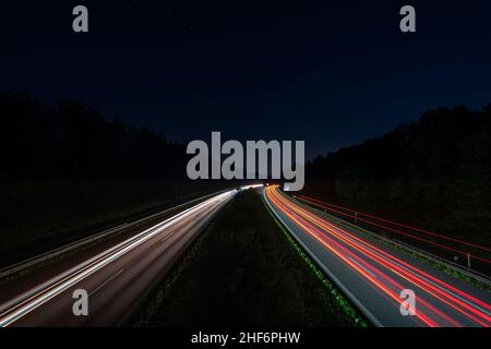 Des pistes lumineuses d'une autoroute de circulation depuis le devant de la voiture et les phares, passant rapidement le point de vue Banque D'Images