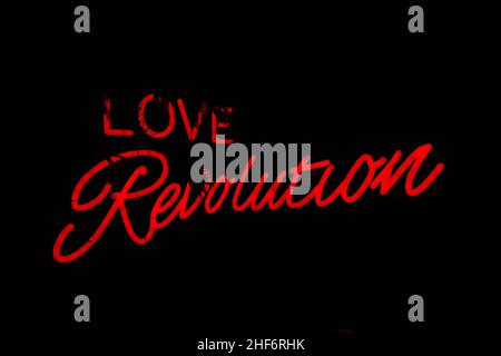 Un néon Love Revolution signe dans le rose chaud.Citation inspiration.Arrière-plan urbain frais. Banque D'Images