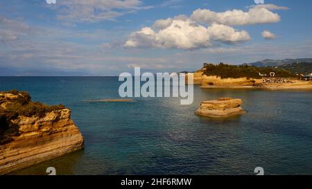 Grèce, Iles grecques, Iles Ioniennes, Corfou, côte nord,Formations rocheuses bizarres sur la côte, Canal d'amour, ciel bleu, nuages blancs, mer turquoise,bleu et vert, rochers à gauche, îlots rocheux au milieu à droite, côte rocheuse plus loin en arrière-plan Banque D'Images