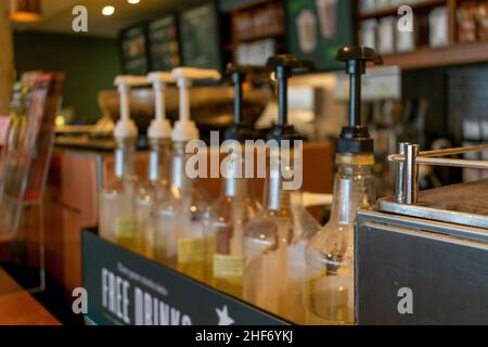 Photo floue de sirops Starbucks avec couvercles en plastique au comptoir dans un café Starbucks de Durham, en Angleterre.Starbucks est un café populaire c Banque D'Images