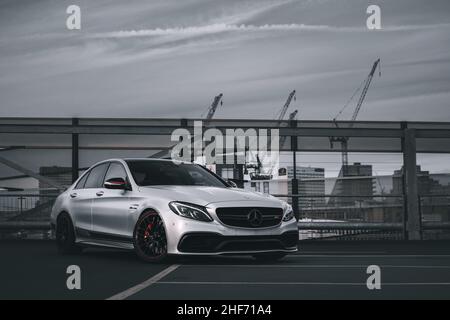 Le devant D'Une berline 2015 Satin Silver Mercedes Benz C63s AMG Edition 1 dans Un parking à plusieurs étages à Manchester Banque D'Images
