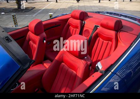 A 2011 Maserati GranCabrio avec intérieur en cuir rouge sièges avant et arrière avec logo Maserati embossé dans les sièges avec le toit abaissé Banque D'Images