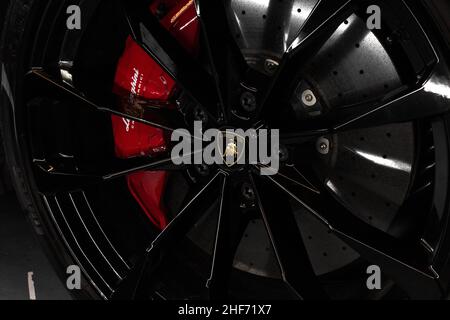 La roue avant en alliage noir brillant avec cache-moyeux Lamborghini et freins carbone-céramique sur Un vus Lamborghini Urus 2020 avec étalonnage de frein Red Lamborghini Banque D'Images