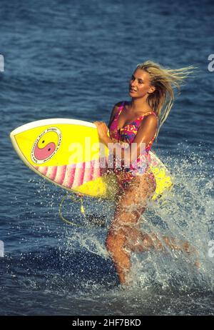 beauté cheveux blond attrayant silhouet sportif avec surf course sur la plage éclabousse un fond d'eau de mer Banque D'Images