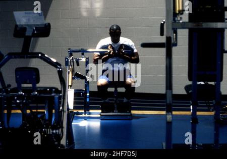 Homme afro-américain faisant de l'exercice dans une salle de gym sur l'équipement d'exercice Banque D'Images