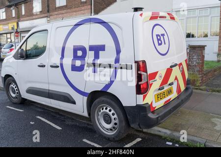 Vue de trois quarts arrière des parcs de fourgonnettes BT blanches sur le côté de la route, imprimée avec le logo en cercle violet en Angleterre au Royaume-Uni Banque D'Images