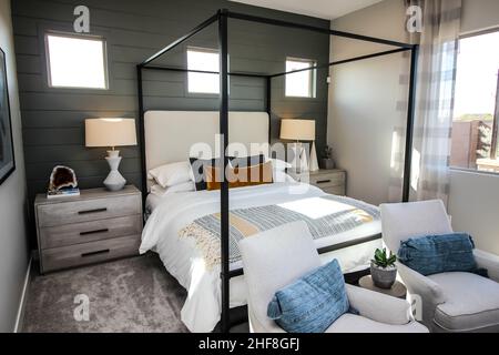 Chambre principale avec lit à baldaquin, lampes, tables de nuit et deux fauteuils Banque D'Images