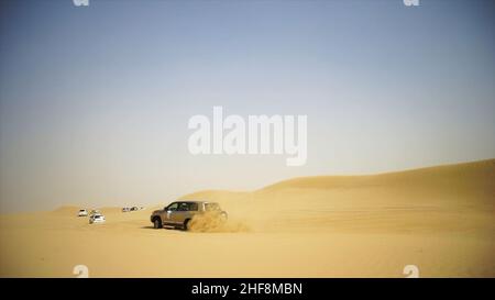 Vue aérienne lors d'une aventure hors route avec un 4x4 dans le désert arabe au coucher du soleil avec les gratte-ciel de Dubaï ou le paysage urbain.Excursion dans le désert avec SUV.Offroad SUV dans Banque D'Images