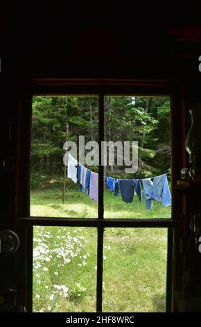 En train de jeter un coup d'œil à une fenêtre de cabine sur des vêtements fraîchement lavés sur une corde à linge. Banque D'Images