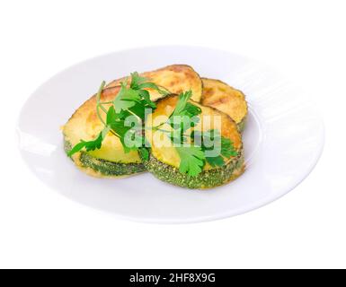 Courgettes frites sur une assiette isolée sur blanc Banque D'Images