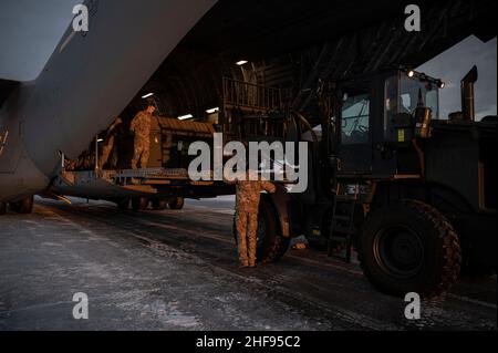 Des aviateurs de la US Air Force de la base interarmées Elmendorf-Richardson (Alaska) déchargent un C-17 Globemaster III, le 11 janvier 2022, à la base aérienne d'Eielson, en Alaska.Le C-17 effectue généralement des missions de transport aérien tactiques et stratégiques, transportant des troupes et du fret dans le monde entier; les rôles supplémentaires comprennent l'évacuation médicale et les fonctions de chute d'air.(É.-U.Photo de la Force aérienne par Airman 1st classe Elizabeth Schoubroek) Banque D'Images