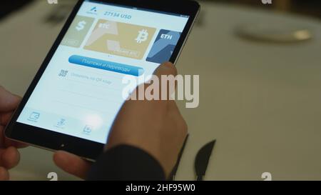 Payer un restaurant avec de l'argent en bitcoin avec une tablette sans fil sur un terminal de carte de crédit.Recevoir de l'argent bitcoin avec un smartphone wir Banque D'Images