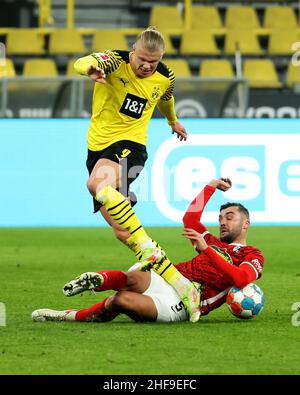 Dortmund, Allemagne.14th janvier 2022.Erling Haaland (en haut) de Dortmund rivalise avec Manuel Gulde de Freiburg lors de la première division allemande Bundesliga football match entre Borussia Dortmund et SC Freiburg à Dortmund, Allemagne, 14 janvier 2022.Credit: Joachim Bywaletz/Xinhua/Alay Live News Banque D'Images