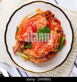 Crabe de boue de Chili, crabe avec sauce Singapourienne, cuisine spéciale de Singapour.Servi sur une assiette blanche Banque D'Images