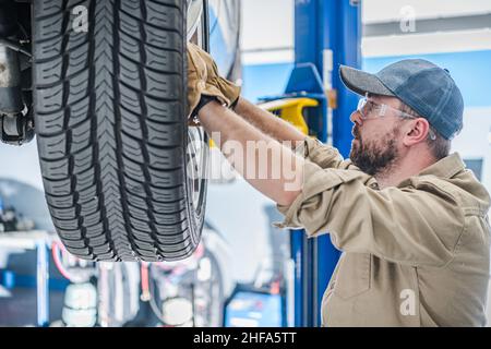 Concessionnaire Auto Service Worker Remplacement des roues de voiture.Technicien automobile de Caucasien faisant un travail dans son lieu de travail.Industrie du transport. Banque D'Images