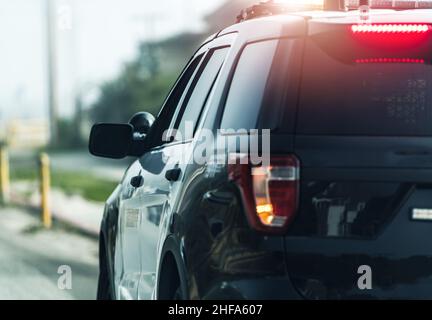 Véhicule de patrouille d'État de la police qui reste sur le côté de l'autoroute avec des feux clignotants.Contrôle de la circulation. Banque D'Images