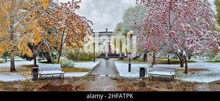 Coin confortable du parc de la ville d'automne après la première chute de neige - paysage de la fin de l'automne ou du début de l'hiver.Feuillage d'automne coloré, baies rouges de rowan et application sauvage Banque D'Images