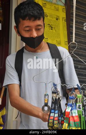 Mandi, Himachal Pradesh, Inde - 08 02 2021: Un homme asiatique choisissant le souvenir tibétain dans la boutique tibétaine avec le port du masque facial pendant la pandémie du coronavirus Banque D'Images