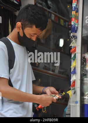 Mandi, Himachal Pradesh, Inde - 08 02 2021: Un homme asiatique choisissant le souvenir tibétain dans la boutique tibétaine avec le port du masque facial pendant la pandémie du coronavirus Banque D'Images