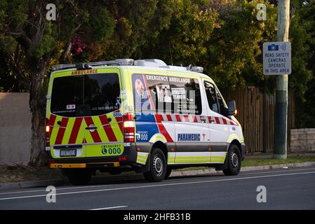 Ambulance véhicule paramédical Victoria stationné sur le côté de la route, feux de détresse allumés, avec message d'agression et de lutte contre la violence Banque D'Images