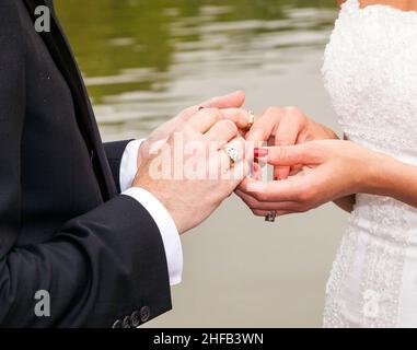 le couple de mariage est attachant la loyauté à vie dans le parc lors de la cérémonie de mariage Banque D'Images