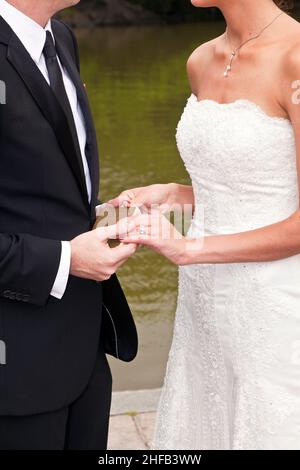 le couple de mariage est attachant la loyauté à vie dans le parc lors de la cérémonie de mariage Banque D'Images