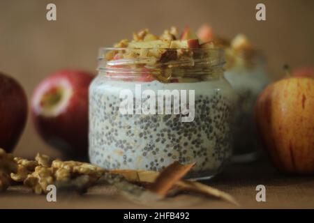 Avoine avec mangue et amandes.Fait en trempant des flocons d'avoine et des graines de chia dans du lait servi avec des pommes hachées, de la cannelle, des amandes et du miel pour Banque D'Images