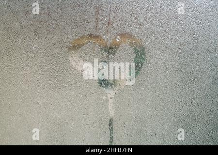 coeur, forme de coeur dessinée à la main sur la surface de verre à la vapeur ou fenêtre avec gouttes de pluie par temps pluvieux. gouttes de pluie sur fenêtre avec espace de copie, sélectif fo Banque D'Images