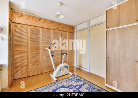 Belle chambre avec machine à faire de l'exercice et armoire en bois Banque D'Images