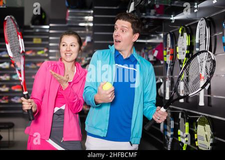 Fille et homme en uniforme choisir la fusée de tennis Banque D'Images