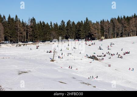 Oberried, Allemagne.15th janvier 2022.Les excursions se tiennent avec des traîneaux sur un pré couvert de neige, tandis que les voitures garées se tiennent au bord de la route ci-dessus.Les week-ends par beau temps, de nombreux skieurs et amateurs d'excursions sont actuellement attirés par le Schauinsland et les montagnes environnantes, ce qui entraîne également un volume élevé de trafic.Credit: Philipp von Ditfurth/dpa/Alay Live News Banque D'Images